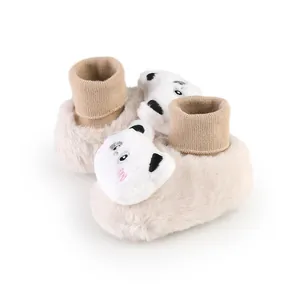 Detailweergave van pluche beige babyschoentjes met schattige ijsbeer
