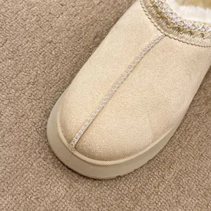 Primer plano de zueco de nieve beige con forro de felpa, cuello trenzado y costura central
