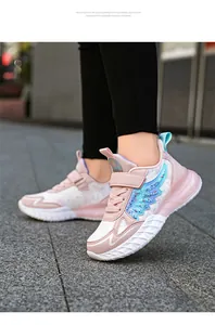 Vista lateral de zapatillas deportivas rosas para niña con diseño de alas brillantes