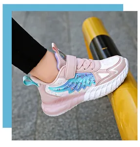 Vista lateral de zapatillas rosas para niña con motivo de ala azul brillante y suela blanca