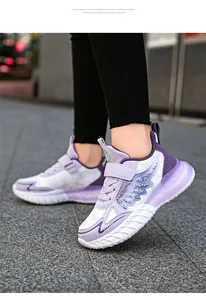 Detalle lateral de zapatillas deportivas moradas y blancas para niña con alas brillantes
