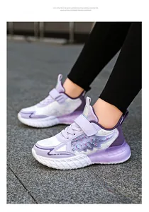 Detalle de las zapatillas blancas y púrpuras para niña con alas brillantes y suela ligera EVA