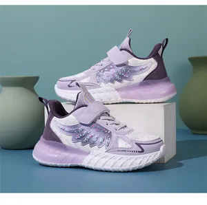 Zapatillas moradas y blancas para niña con diseño de alas brillantes en un soporte de exhibición.