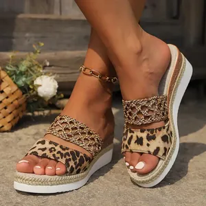 Close-up of leopard print wedge sandals with rope-wrapped platform sole and braided straps.