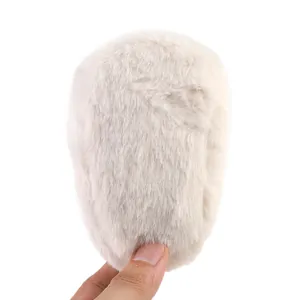 Detailopname van de zachte beige pluche babyschoen met gedetailleerde pluizige bonttextuur