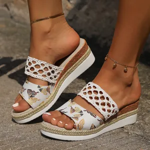 Detail view of women's butterfly print wedge slippers with white braided straps and platform