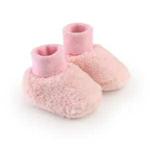 Detailopname van zachte roze pluizige baby winterschoentjes met elastische gebreide boorden
