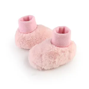 Detail van zachte roze pluizige babyschoentjes met een warme gebreide boord