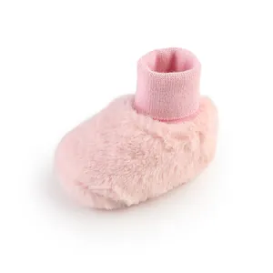 Detailweergave van zachte roze pluche baby winterschoen met gebreide enkelboord
