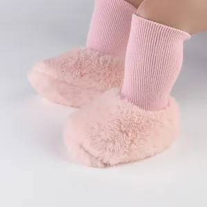 Detail van roze pluizige fleece-gevoerde baby-sokschoenen voor winterse stappen