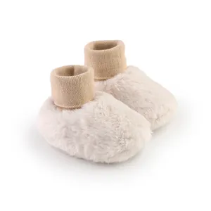 Detailopname van warme beige pluche baby winterschoentjes met zachte imitatiebont textuur