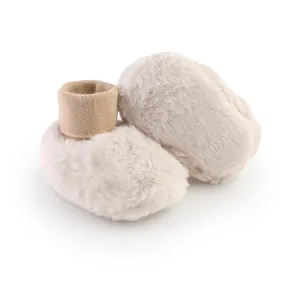 Detailopname van het zachte pluizige materiaal en gebreide manchetten van baby-winterlaarzen