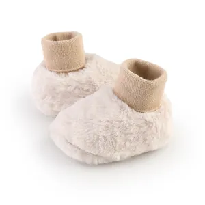 Gedetailleerd overzicht van warme beige baby winterschoenen met zachte gebreide manchetten