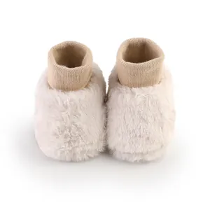 Detailweergave van beige pluche babyloopschoenen voor de winter met gebreide boorden
