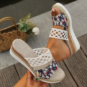 Detailed view of women's wedge sandals with floral pattern and rope-braid platform sole.
