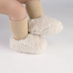 Detailopname van pluche crème babyloopschoentjes met geïntegreerde bruine sokken