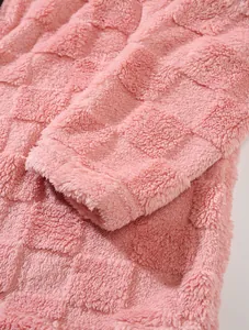 Close-up macro detail showing the soft texture of thick pink fleece with a checkered pattern