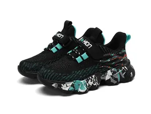 Detalle de zapatillas negras para niño con detalles en verde azulado y suela salpicada