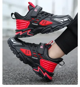 Vista detallada de las zapatillas de deporte de cuero negro y rojo para niños con velcro.
