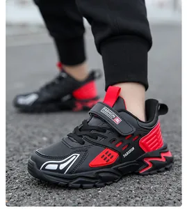 Detalle de zapatillas de deporte negras y rojas para niños con acabado en cuero
