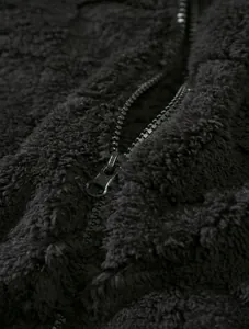 Close-up of black sherpa fleece texture and smooth zipper detail for men's winter hoodie