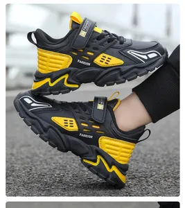 Vista lateral detallada de las zapatillas deportivas de cuero negro y amarillo para niños