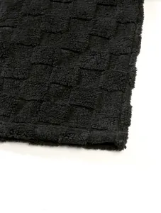Macro detail of thick black fleece lining with checkered pattern on winter hoodie top