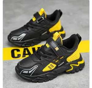 Primer plano de zapatillas de correr para niños en negro y amarillo con suela gruesa