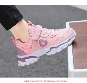 Detailed side view of pink girls' running shoes with heart pattern and velcro strap
