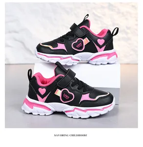 Detailed side view of girls' black and pink sneakers with heart motifs and velcro straps.