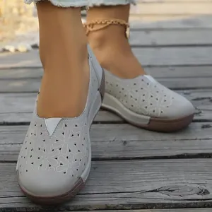 Primer plano detallado de zapatos casuales grises con elegantes detalles florales calados