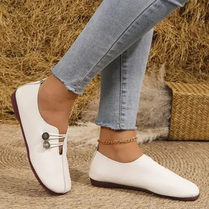 Close-up of elegant white soft leather loafers with round toe and textured finish