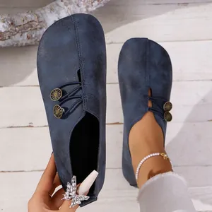 Detailed view of women's vintage blue soft leather slip-on loafers with decorative buttons