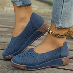 Vista detallada de mocasines azules con patrones florales cortados con láser en deck