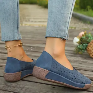 Detalle de zapatos planos casuales azules con patrones florales étnicos calados
