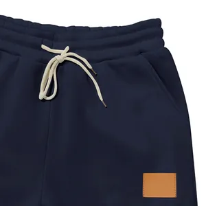 Primer plano de la cintura con cordón y el parche de cuero marrón en el pantalón azul
