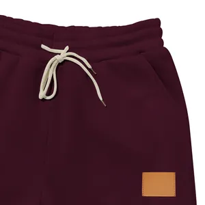 Primer plano de la cintura de pantalones burdeos con cordón y parche de cuero