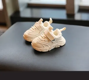 Primer plano de zapatillas blancas para bebés con suelas blandas para caminar seguro.