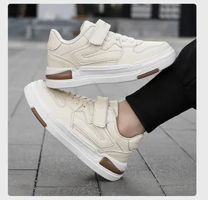 Gedetailleerd zijaanzicht van crèmekleurige kindersneakers met bruine accenten.