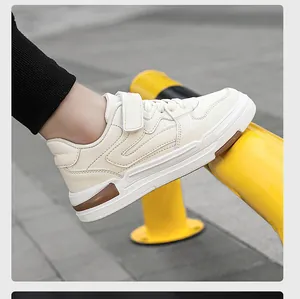 Zijaanzicht van beige leren kindersneakers met klittenbandsluiting in een straatsetting