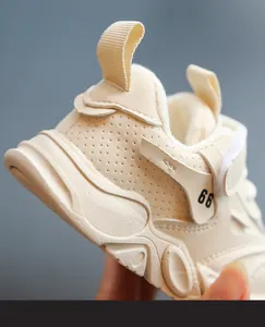 Vista detallada de la zapatilla crema para niños con estampado 66 y tirador