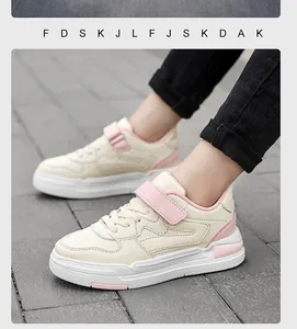 Detailweergave van kindersneakers in crème en roze met verstelbare klittenbandsluiting