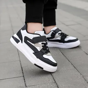 Zwart-witte kinderleren sneakers met klittenband en veters voor actieve jongens en meisjes