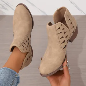 Primer plano de botines caqui calados con tacón ancho y detalles de corte láser.
