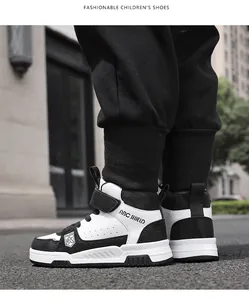 Vue détaillée de baskets montantes pour enfants avec scratchs en cuir noir et blanc