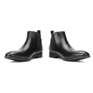 Side view detail of stylish men's black Chelsea boots with a square toe design on white
