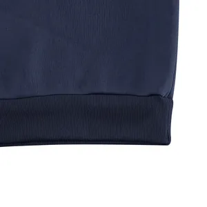 Macro view showing the high-quality ribbed hem and texture of a navy blue sweatshirt