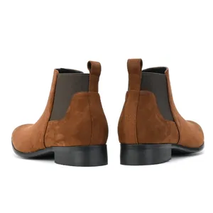 Back view of classic brown suede men's Chelsea boots featuring square toe and elastic panels