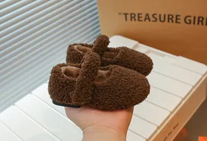 Nahaufnahme von braunen Plüsch-Lammwoll-Kinderschuhen mit weichem, warmem Futter.