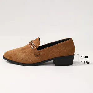 Gedetailleerd zijaanzicht van bruine suède loafers met spitse neus en hak van 4 cm.